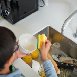 industrious boy cleaning the dishes