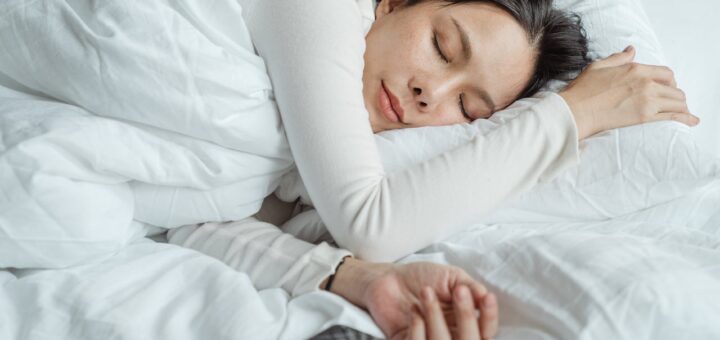woman sleeping in bed near smartphone